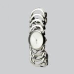 Watches And Jewelry Woman - a white clock sitting on top of a metal bracelet