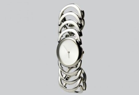 Watches And Jewelry Woman - a white clock sitting on top of a metal bracelet