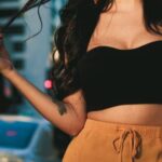 Stylish Accessories - Woman Wearing Black Crop Top and Orange Skirt Standing