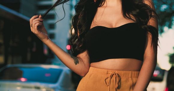 Stylish Accessories - Woman Wearing Black Crop Top and Orange Skirt Standing