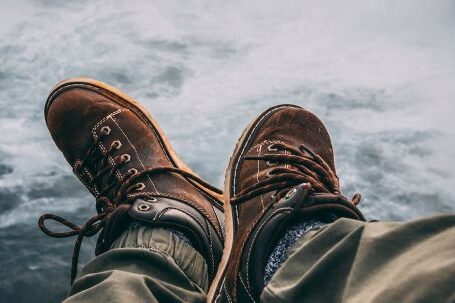 Adventure Footwear - Person Sitting on Rock Near Waterfalls