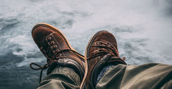 Adventure Footwear - Person Sitting on Rock Near Waterfalls