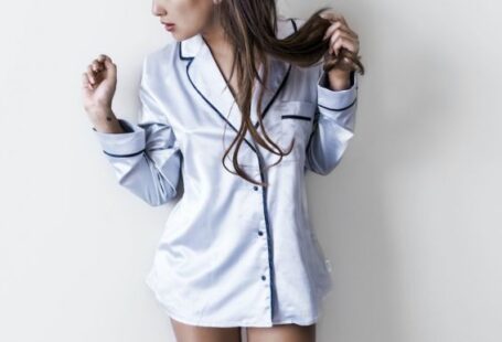 Pajama - woman in white and black button-up coat leaning on wall